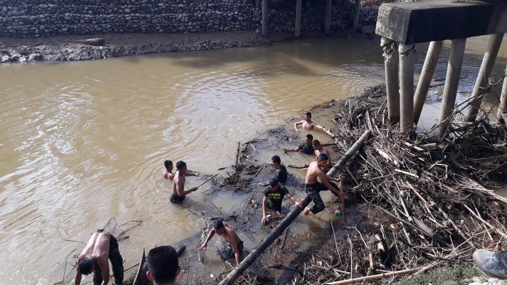 Anggota Satgas TMMD Ke-104 KODIM 0425/Seluma Membersihkan Sampah Kayu Di Sungai Maras