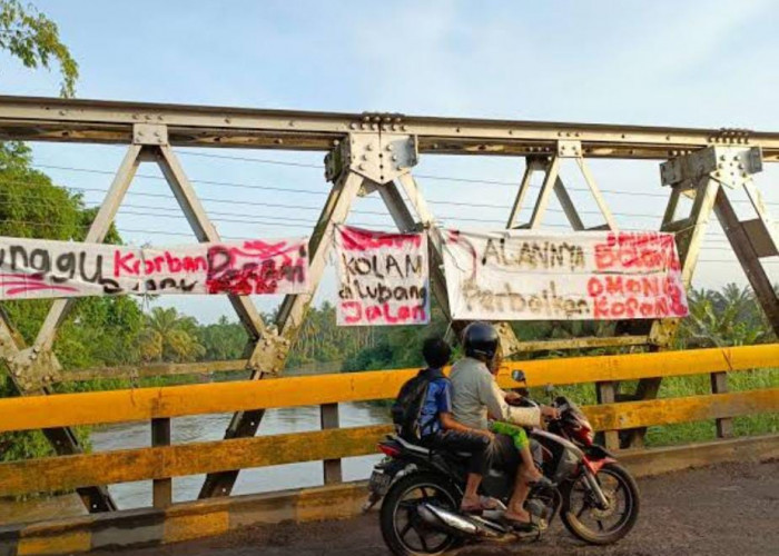 Jalan Berlobang Tak Kunjung Diperbaiki, Warga Pasang Spanduk di Jembatan Rawa Makmur 
